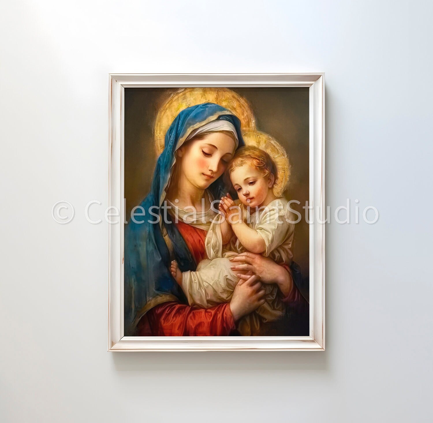 Mary holding baby Jesus. Mary, in a blue headscarf and red dress, gazes down affectionately at Jesus, who appears to be in prayer or blessing, clad in white. The soft glow and warm tones give the artwork a serene, holy ambiance.